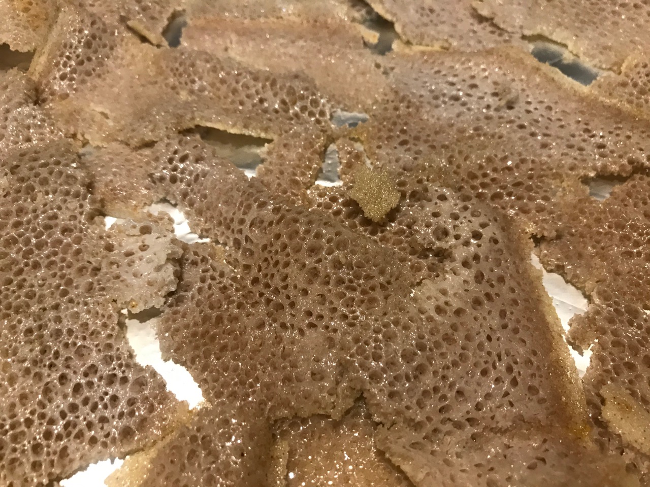 close up of pre-baked injera chips on a tray