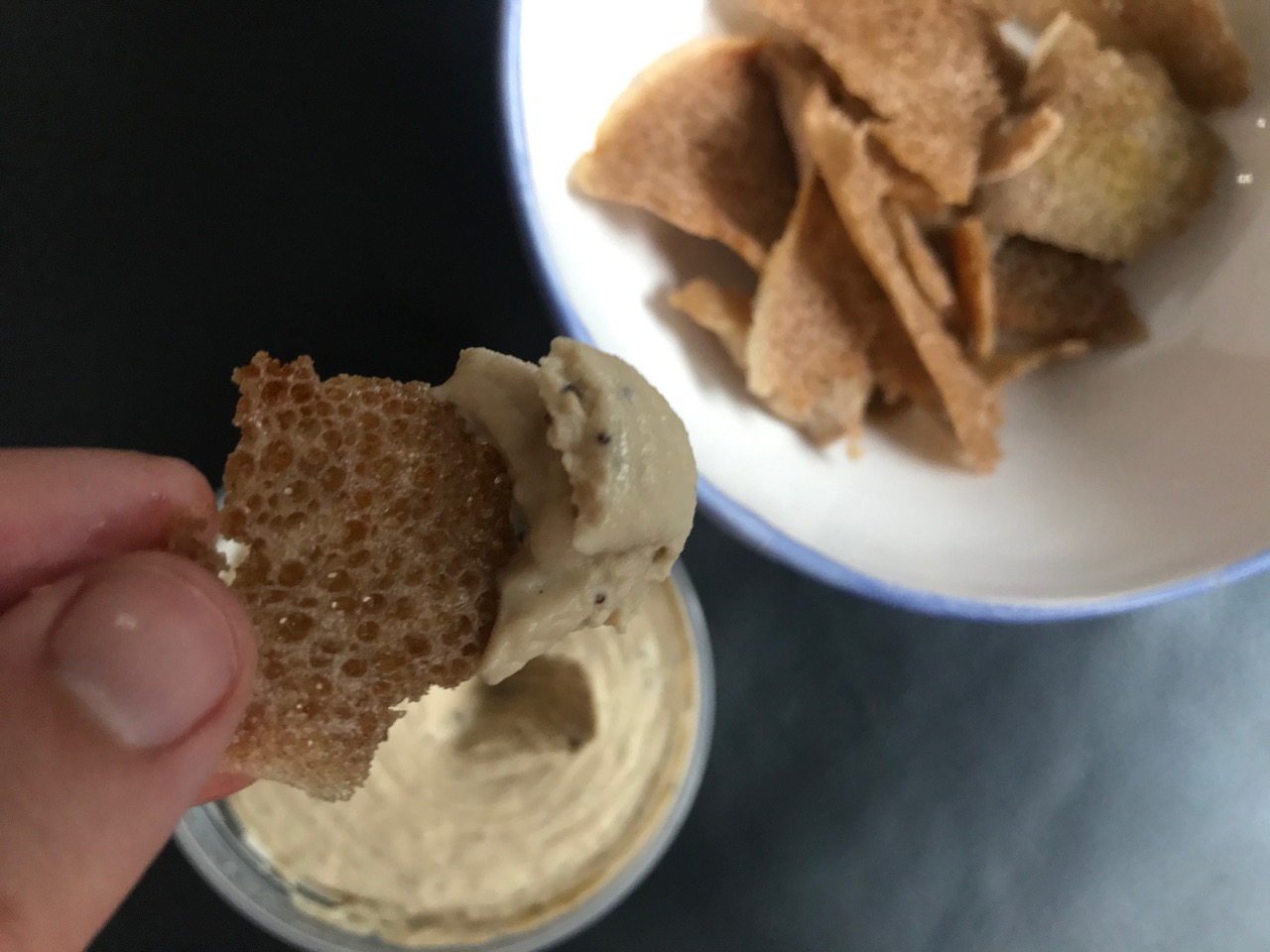 close up on chip dipped in hummus